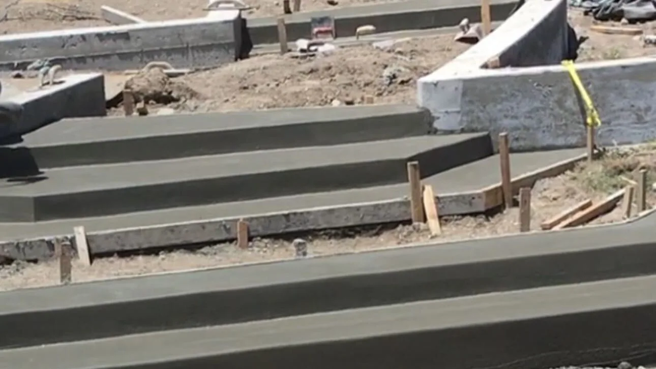Freshly poured concrete steps and curbs still held in their timber forms