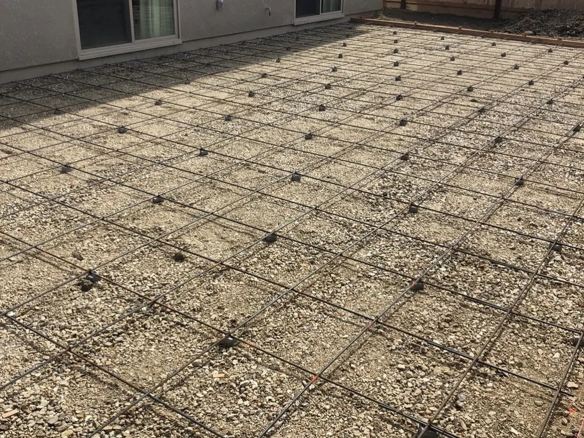 Tied rebar grid raised on chairs over a compacted base ready for concrete