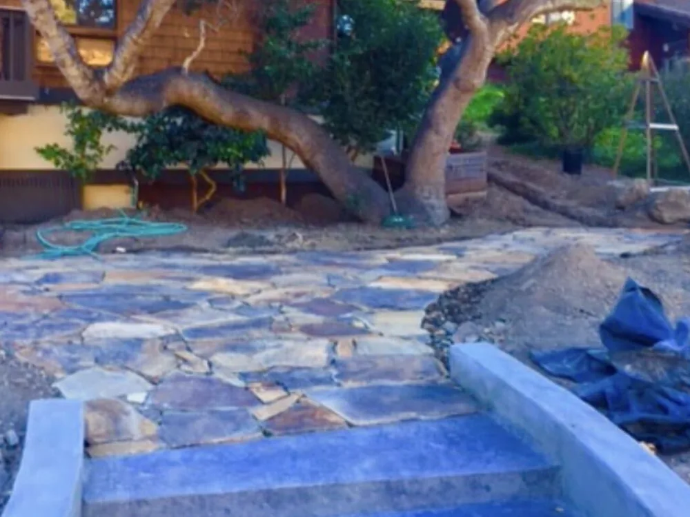 Flagstone patio going in around new poured concrete steps and curbs