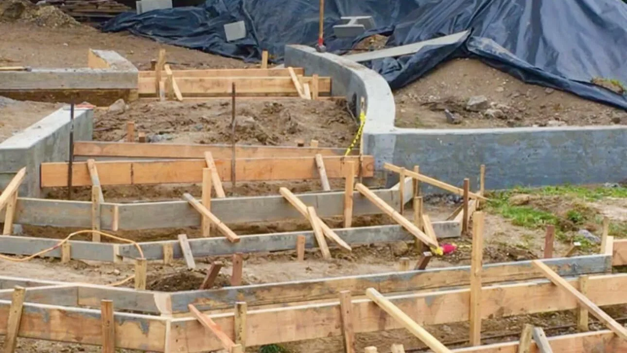 Timber formwork laid out for concrete steps and low walls on a slope