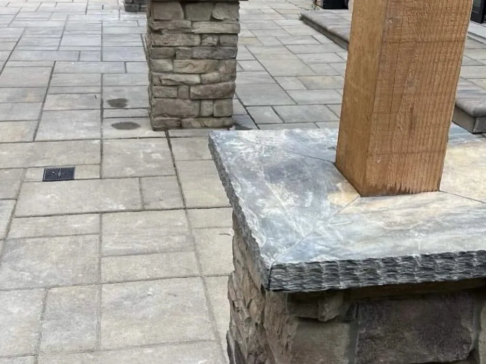 Paver patio with stone veneer column bases by Aguilar and Sons Construction