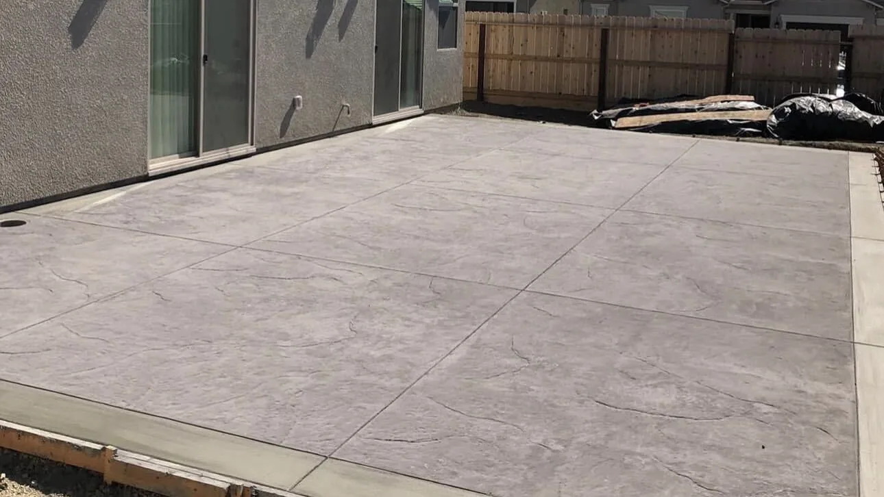 Finished textured concrete patio along a stucco home by Aguilar and Sons Construction, serving Seaside, CA