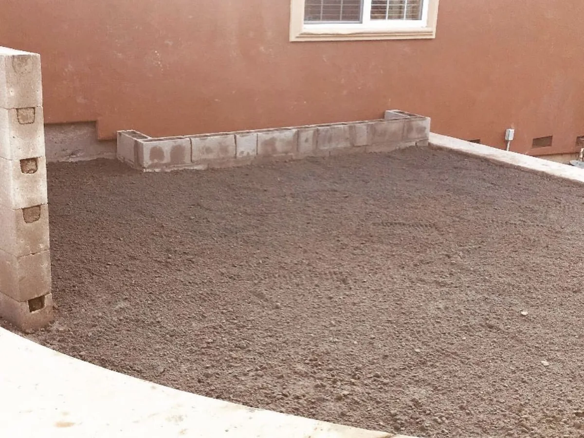 Compacted base inside timber forms with a block column and stucco wall