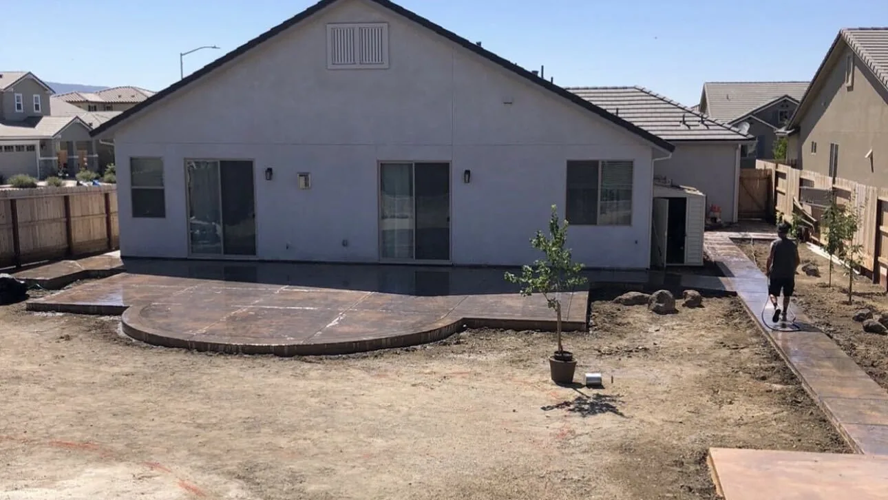 Finished colored stamped patio with a rounded bay by Aguilar and Sons Construction